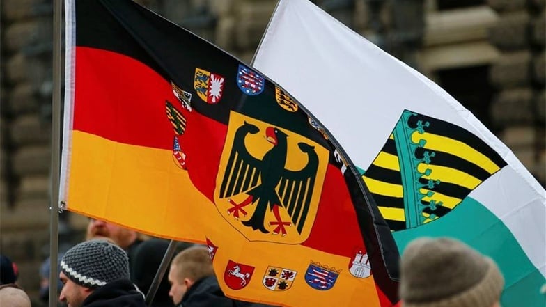 Vor allem Deutschlandfahnen sind bei den Pegida-Anhängern zu sehen, aber auch die von Sachsen.