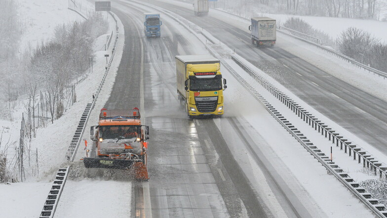 Der Winterdienst schiebt auf der Autobahn A17 im Erzgebirge den Schnee von der Fahrbahn.