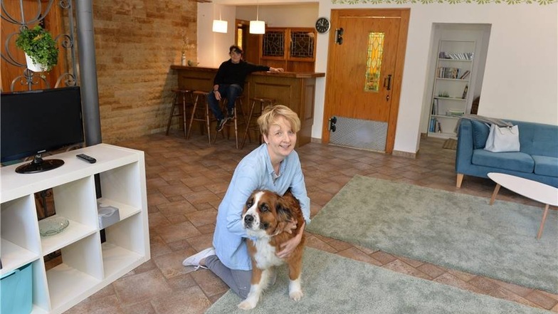 Maika Hochberger ist hier mit dem Hund Dala in der früheren Gaststube, jetzt das Gemeinschaftswohnzimmer.