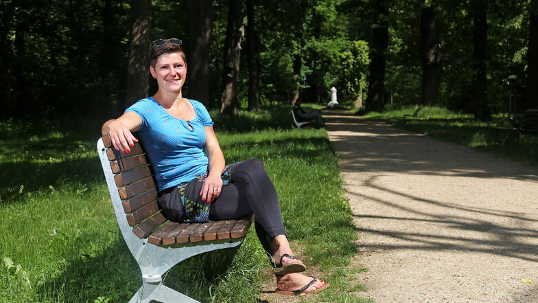 Susanne Braune auf einer der Bänke im Riesaer Stadtpark: Die 36-Jährige würde gern für weitere Sitzgelegenheiten im Park sorgen.