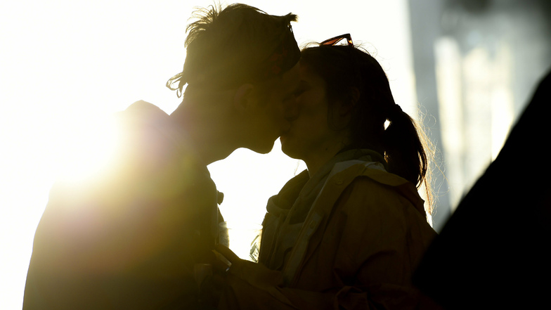 Ein junges Pärchen küsst sich im Sonnenuntergang. Und ja: Hitze wirkt sich tatsächlich auf das Sex-Leben aus.