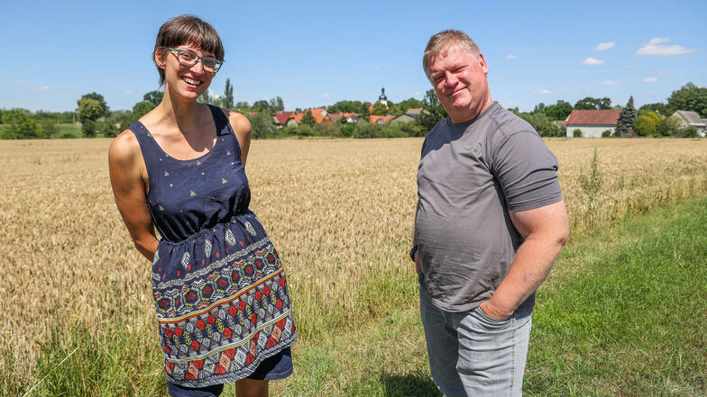 Nia von der Initiative "AAA Pödelwitz" und Jens Hausner, Sprecher der Bürgerinitiative "Pro Pödelwitz", stehen vor dem Dorf. Beide kämpfen für eine Zukunft für Pödelwitz ohne Kohle.