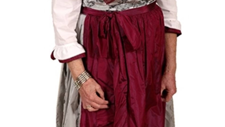Die einzige Frau im Dirndl. Die elegante Tracht von Anne-Marie Schipporeit aus Bayern ist eine Maßanfertigung für 3 000 Euro. Passendes Detail: ein geflochtener Zopf.