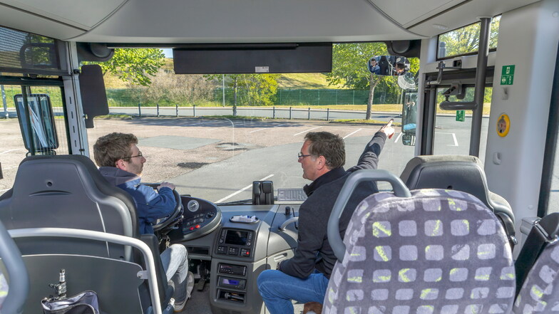 Fahrlehrer Enrico Gerber (r.), der seit Jahrzehnten unter anderem angehende Busfahrer ausbildet, zeigt SZ-Reporter Eric Weser, worauf es beim Blick in die Spiegel ankommt.