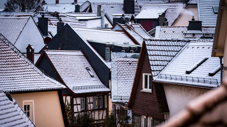 Frisch gefallener Schnee liegt auf den Dächern von Häusern.
