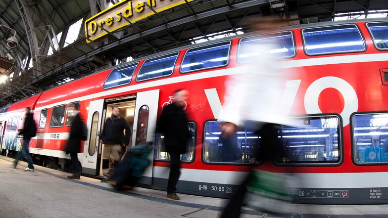 Trio läuft in Dresden-Neustadt vor einem Zug über die Schienen