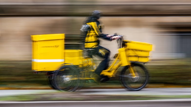 Ein Postbote der Deutschen Post ist in Dresden unterwegs: Unter den acht fehelenden Post-Pflichtstandorten befindet sich auch der Stadtteil Bühlau.