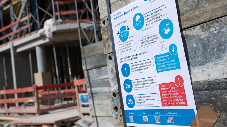 Schilder mit Corona-Informationen an einer Baustelle. Das Bauhandwerk scheint die Krise ganz gut zu überstehen. Anderen Handwerksbetrieben geht es auch im Landkreis Meißen schlechter.