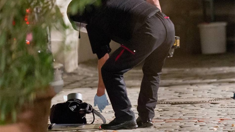 Ein Polizist bückt sich in der Nacht zum Montag in Ansbachnach dem Rucksack eines 27-jährigen der zuvor einen Sprengsatz zur Explosion gebracht hatte.