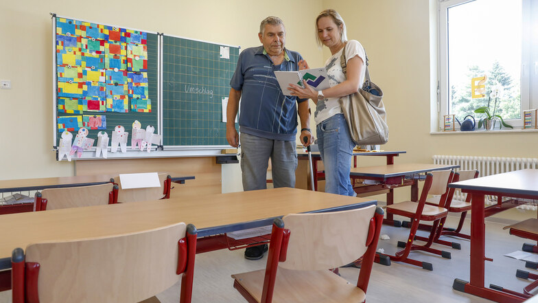 Bürgermeister Günther Ohmann und Rica Hänel vom Bauamt der Gemeinde Olbersdorf stehen in einem der neu gestalteten Klassenräume der Bertsdorfer Grundschule.