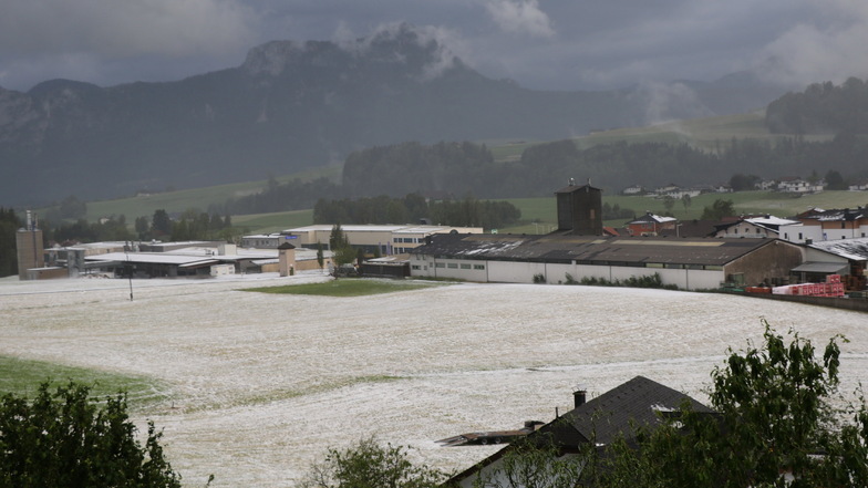 Österreich, Salzburg: Hagel liegt nach einem Unwetter auf einem Feld.