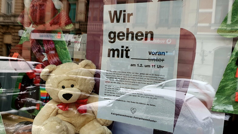 Der Teddy blickt freundlich, doch die Händler machen sich Sorgen. Das zeigt das Plakat im Schaufenster vom Strumpfhaus Hempel in der Gartenstraße in Pirna.