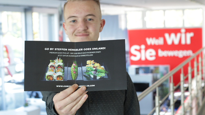 Stanley Klemke, Auszubildender im Hoyerswerdaer Toyota-Autohaus Schiefelbein, zeigt den Flyer, der Appetit auf Hensslers Premium-Sushi macht.