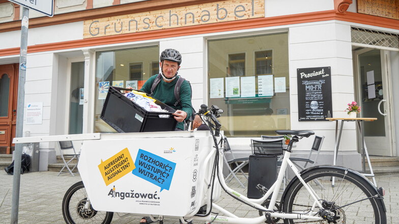 Eckart Riechmann von der Initiative Teilrad Bautzen holt mit dem Lastenrad Wäsche vom Restaurant Grünschnabel ab, bringt sie zum Waschsalon und wieder zurück.