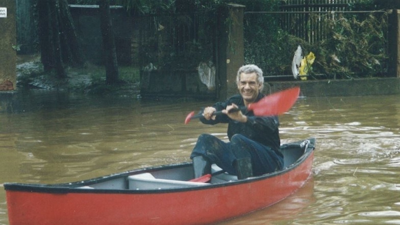 Es ist Jörg Diecke aus Grimma, der am 14. August 2002 Trocknungsgeräte per Boot zu seinem überfluteten Haus fährt. Ein privates Foto zeigt ihn auf dem Weg dahin.