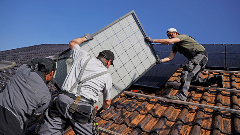 Mitarbeiter der Firma Elektro-Barth aus Röderau bauen eine Photovoltaik-Anlage auf das Dach eines Eigenheimes.