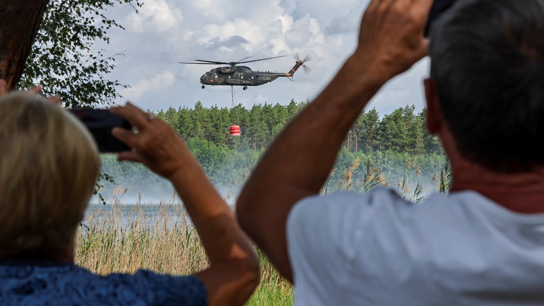 Ein Bundeswehrhubschrauber vom Typ Bell CH-53 holt Löschwasser zur Waldbrandbekämpfung aus dem Kiebitzer Baggerteich.