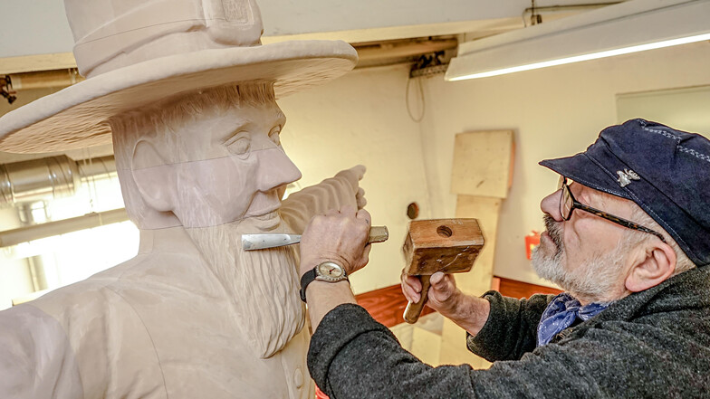 Mit Schnitzeisen verfeinert Holzgestalter Jürgen Spottke die Konturen der neuen Pumphut-Figur. Anschließend wird er sie bemalen.