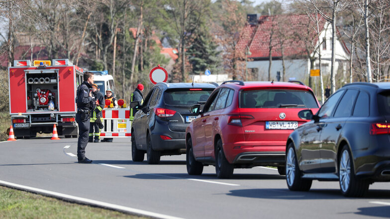 Ein Polizist kontrolliert ein Auto an einer Straßensperre am Ortseingang von Jessen. Seit Donnerstag, 7.00 Uhr, bis mindestens zum 10. April sind Schweinitz und Jessen von der Außenwelt abgeriegelt.