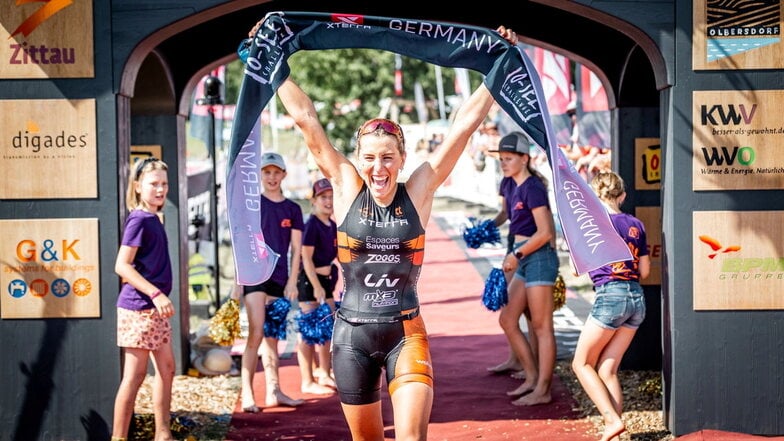 Die Französin Alizee Paties feiert ihren Sieg im Weltcuprennen am Olbersdorfer See. Entscheidend dafür war eine überragende Leistung auf der Radstrecke.