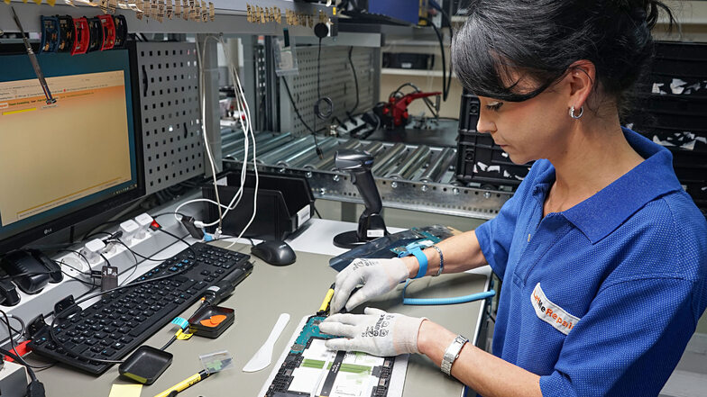 Mit wenigen Handgriffen bringt Anja Hoffmann ein defektes Tablet in Ordnung. Sie gehört zu den rund 50 Mitarbeitern, die in der Kirschauer Betriebsstätte der Firma LetMeRepair elektronische Geräte – vor allem Handys und Tablets – reparieren.