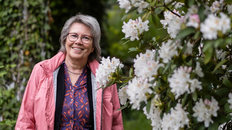 Evelin Mühle steht auf dem Friedhof vor einem blühenden Rhododendron. Nach 41 Jahren geht sie nun in den Ruhestand.