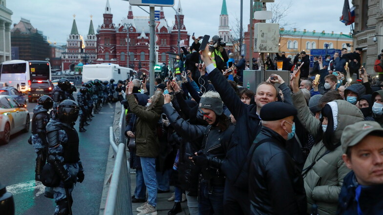 Polizisten stehen in Moskau Demonstranten gegenüber, die während eines Protests zur Unterstützung des inhaftierten Oppositionsführers Nawalny ihre leuchtenden Handys in die Höhe halten.