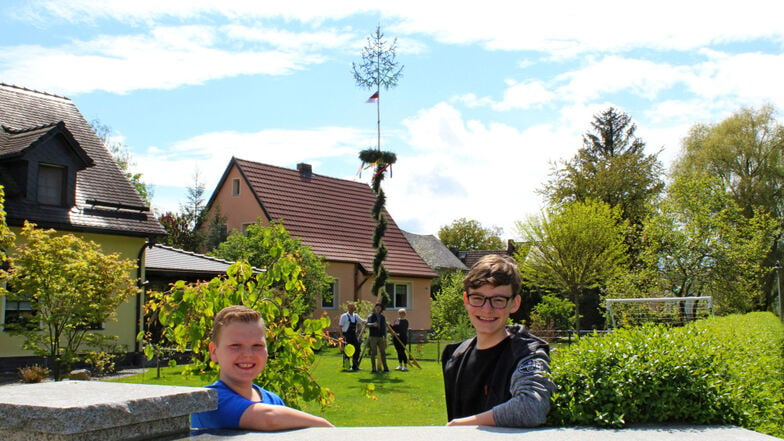 Lukas Kummer (links) und Tobias Crüger (rechts) sowie Daniel und Susann Kummer und Paul Graf vom Jugendclub (Bildmitte) freuen sich über die besondere Aktion des Maibaumstellens. Im Garten von Kummers steht dieses Exemplar.