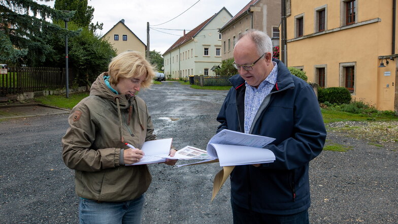 Bürgermeister Frank Schöning erläutert SZ-Reporterin Annett Heyse die Baupläne für den Rundling in Sobrigau.