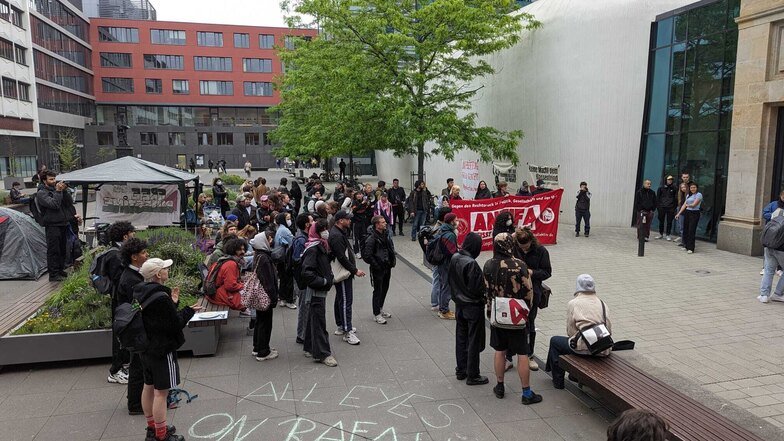 50 bis 60 Protestler stehen auf dem Leibnizforum vor dem Uni-Gebäude.