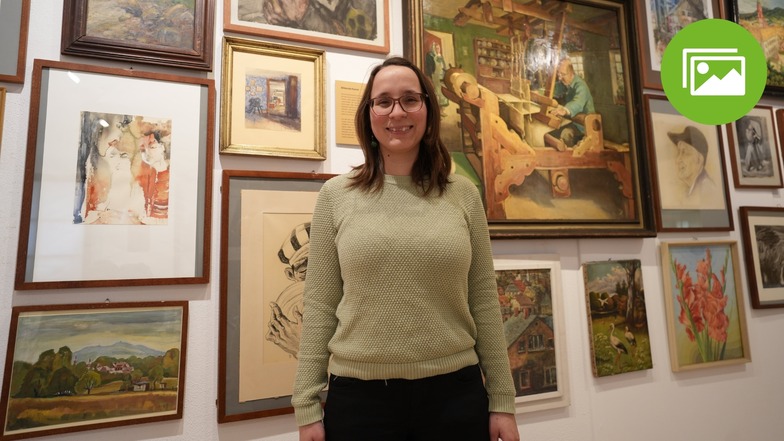 Museumspädagogin Hannah Knittel umgeben von einer Fülle von Bildern im Löbauer Museum. Aktuell läuft hier die große Geburtstagsschau.