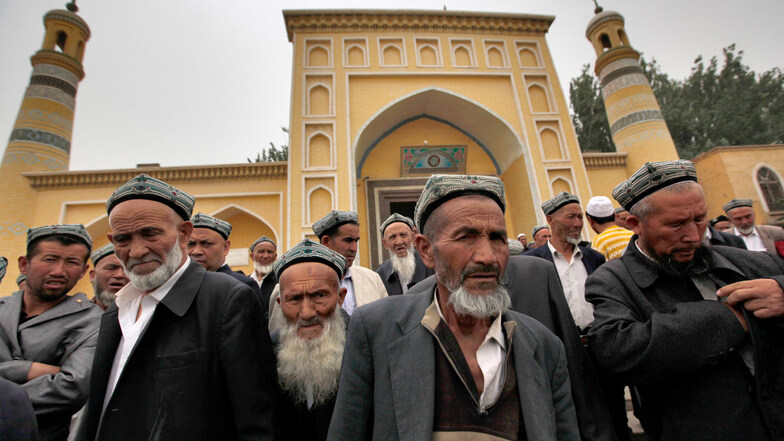 Muslimische Männer der Uiguren kommen 2013 im chinesischen Kashgar aus der Id Kah Moschee nach den Freitagsgebeten. 