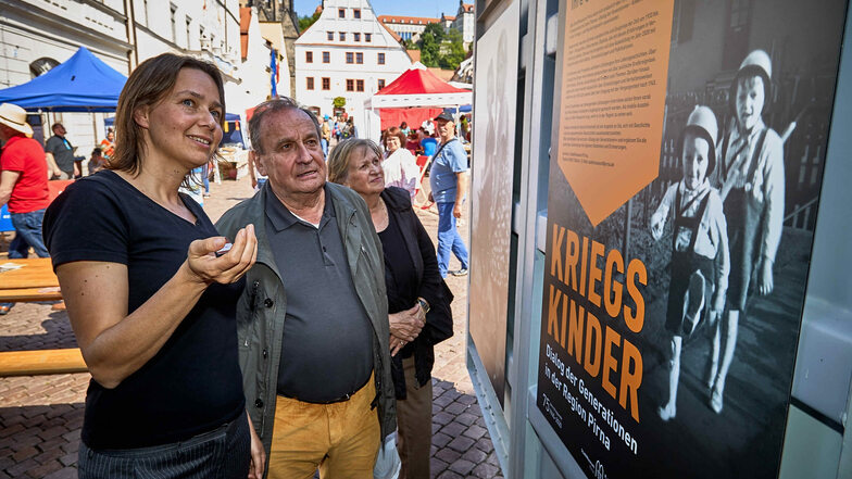 Pirnas Stadtmuseum geht auf Tour und sammelt Erinnerungen: Katrin Purtak (vorn) erläutert Erhard und Renate Spacek aus Pirna am Museumscontainer auf dem Markt der Kulturen das Projekt „Kriegskinder“.