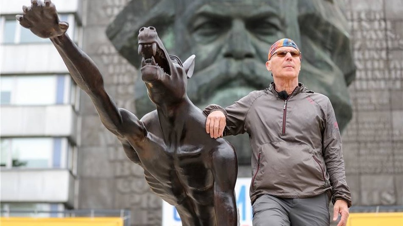 Bildhauer Rainer Opolka steht neben einem Bronze-Wolf