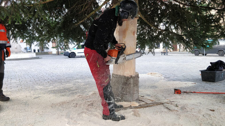 Was hier aussieht wie Schneeflocken sind Sägespäne. Stefan Vollhardt sägt den Baum etwas dünner, damit er in die vorbereitete Hülse passt.