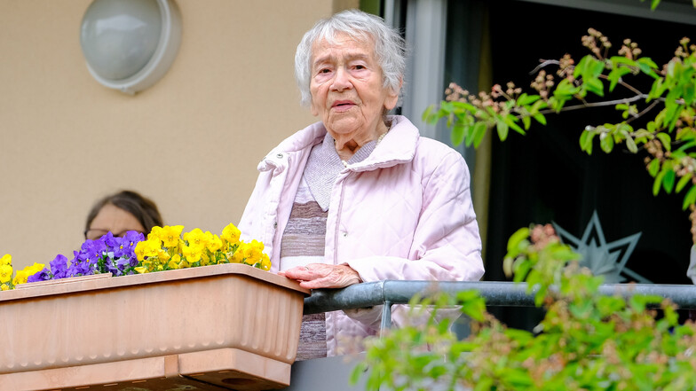 Sicherer Abstand: Gerührt lauscht die 101-jährige Jubilarin auf ihrem Balkon im Innenhof eines Radebeuler Seniorenwohnparks.