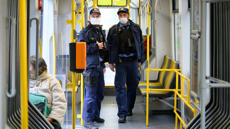 Dresdner Polizisten kontrollieren in der Straßenbahn. Immer wieder kommt es zu Verstößen, teils auch Angriffen wegen der Maskenpflicht.