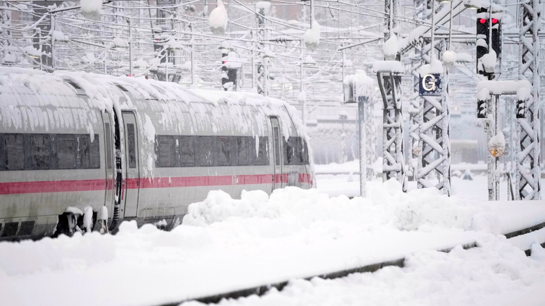 Ein ICE steht nach starkem Schneefall am Hauptbahnhof in München.