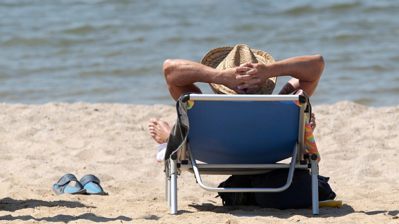 Ostseefeeling: Ein Mann liegt mit einem Sonnenhut auf einer Sonnenliege am Strand des Bärwalder Sees.