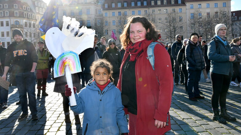 Mathilda und ihre Mutter Anne aus Dresden nehmen mit selbstgebastelter Friedenstaube an der Demo teil.