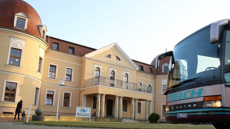 Ein Bus fährt am Schloss Gebelzig vorbei. Hier sind Grundschule und eine Kita untergebracht.