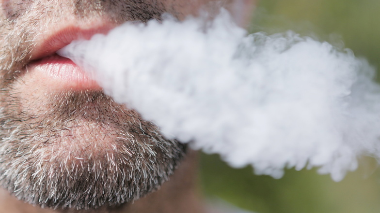 Ein Mann raucht eine E-Zigarette. Eine Mehrheit der Deutschen wünscht sich laut Umfrage ein härteres Vorgehen gegen E-Zigaretten und Tabak-Erhitzer in Nichtraucherbereichen.