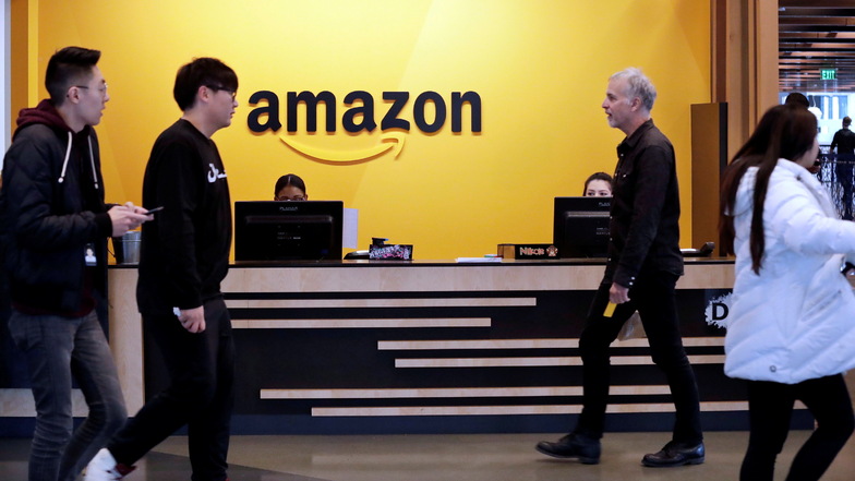 Amazon-Mitarbeiter in einer Lobby der Zentrale in Seattle: Der Online-Versandhändler streicht mehr als 18.000 Stellen.