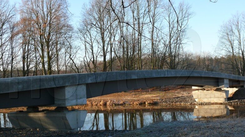 Ein Bild vom letzten Montag: Die neue Brücke schwingt sich schon über den Fluss. Noch steht die alte Brücke (nicht auf dem Foto), aber nicht mehr lange.