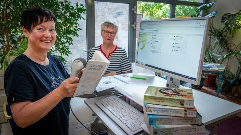 Bibliothekarin Kerstin Otto (links) erklärt Nutzerin Heide Bauer die Vorteile des neuen Leisniger Bibliothekssystems.