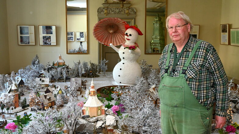 Matthias Riedel steht im Salon vor der winterlichen Landschaft mit Lichterhäusern aus Olbernhau. Die gehörten zur Weihnachtsausstellung, die aber keiner sehen durfte. Nun sind für kurze Zeit noch einige der seltenen Leihgaben zu besichtigen.