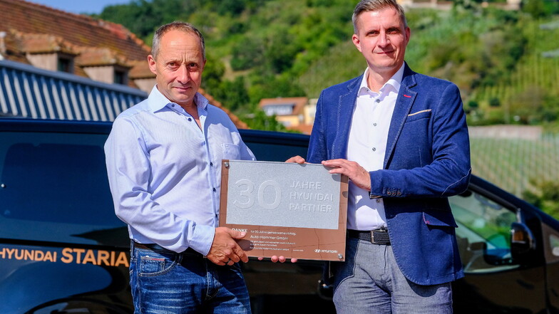 Autohändler Torsten Hammer (l.) bekommt als Anerkennung für seine 30-jährige Vertragspartnerschaft mit Hyundai eine Urkunde sowie eine silberne Plakette von Sebastian Braun, Hyundai- Distriktleiter Vertrieb Region Sachsen, überreicht.