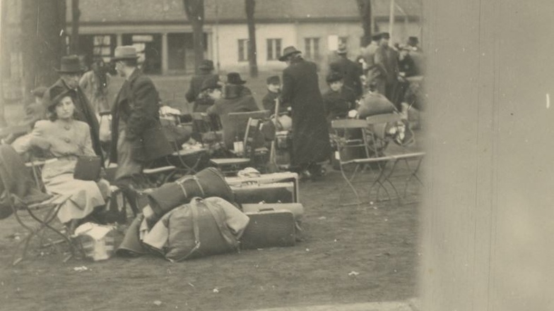 Am 21. November 1941 müssen sich 1.000 Breslauer Juden in einem Gartenlokal versammeln, das Foto zeigt die ersten Ankömmlinge. Sie wirken erschöpft, aber nicht beunruhigt.  Die Menschen ahnen nicht, dass am Ende ihrer Reise der Tod wartet.