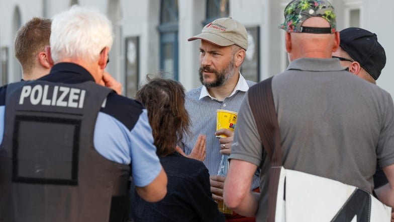 Der Chef der Freien Sachsen, Martin Kohlmann. (Mitte mit Kappe) im Gespräch mit Demoteilnehmern in Herrnhut am 30. März.