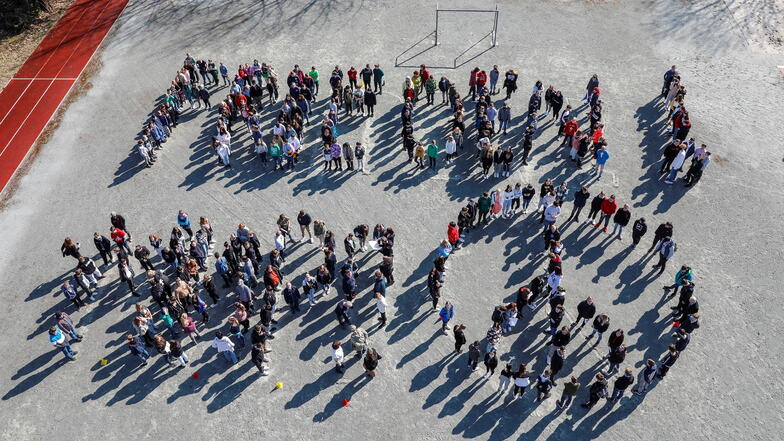 Flashmob auf dem Schulhof: 351 Kinder und Jugendliche haben sich zu den Worten Frieden auf Deutsch und Russisch sowie dem entsprechenden Symbol aufgestellt.